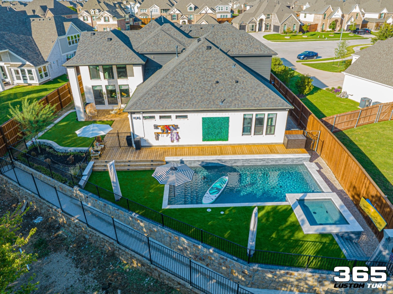 Aerial view of backyard with pool, deck, and turf