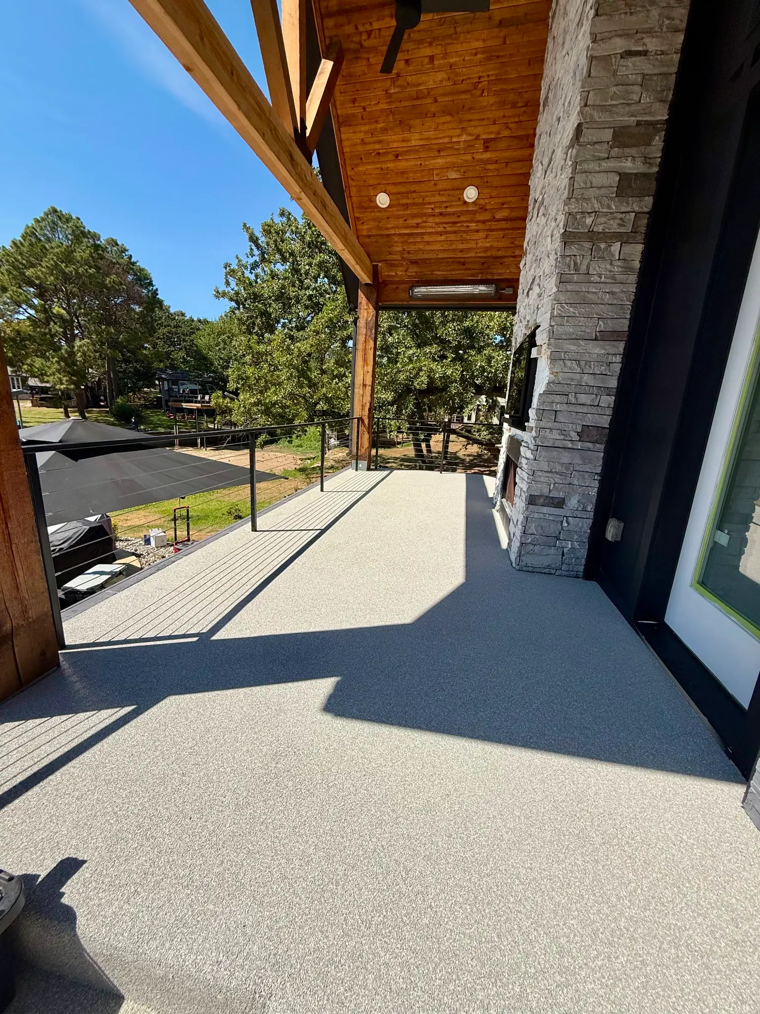 Covered patio with cedar beams, rubber surfacing, and cable railing
