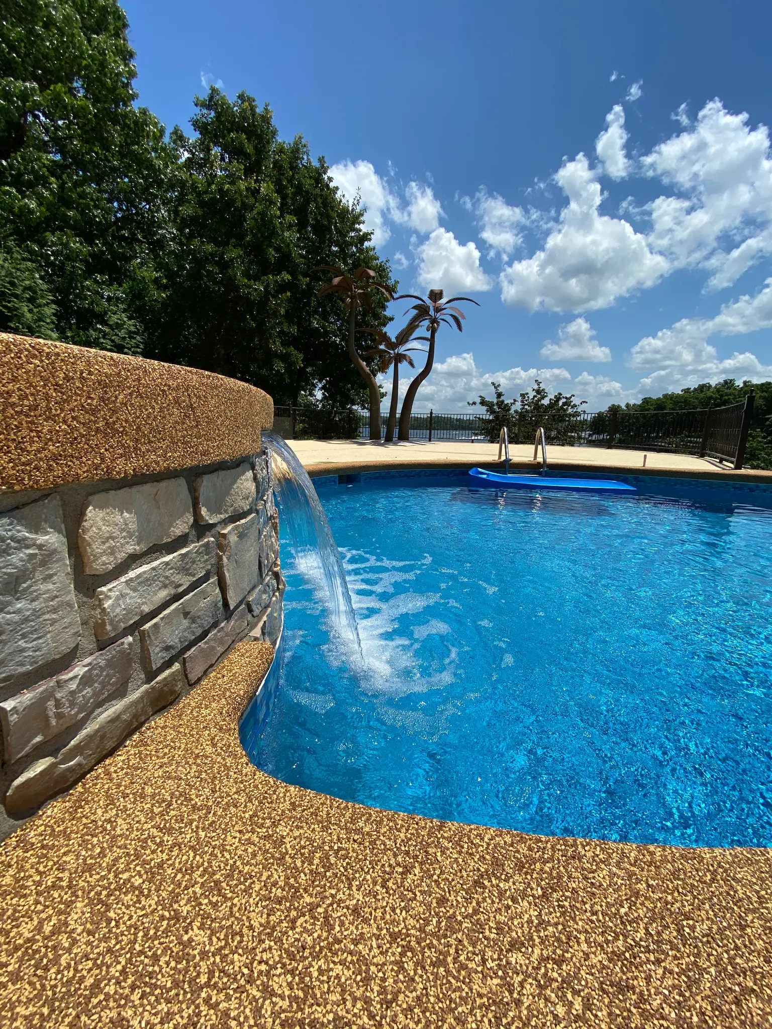 Pool with rubber deck and stone waterfall