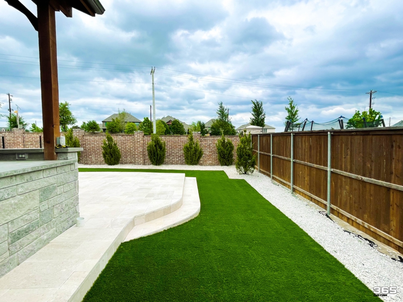 Backyard turf with stone pavers and pergola