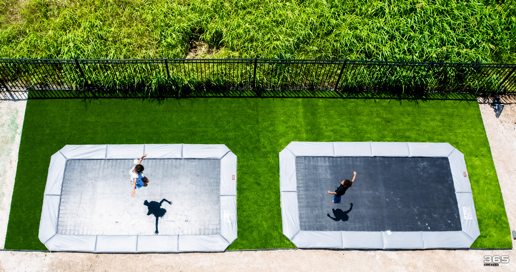 Kids on trampolines with lush turf surround