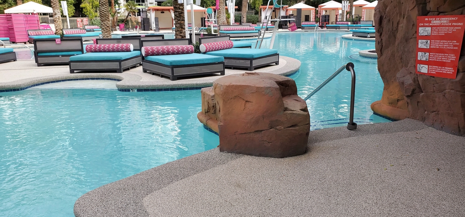 Resort pool area with rock features and loungers