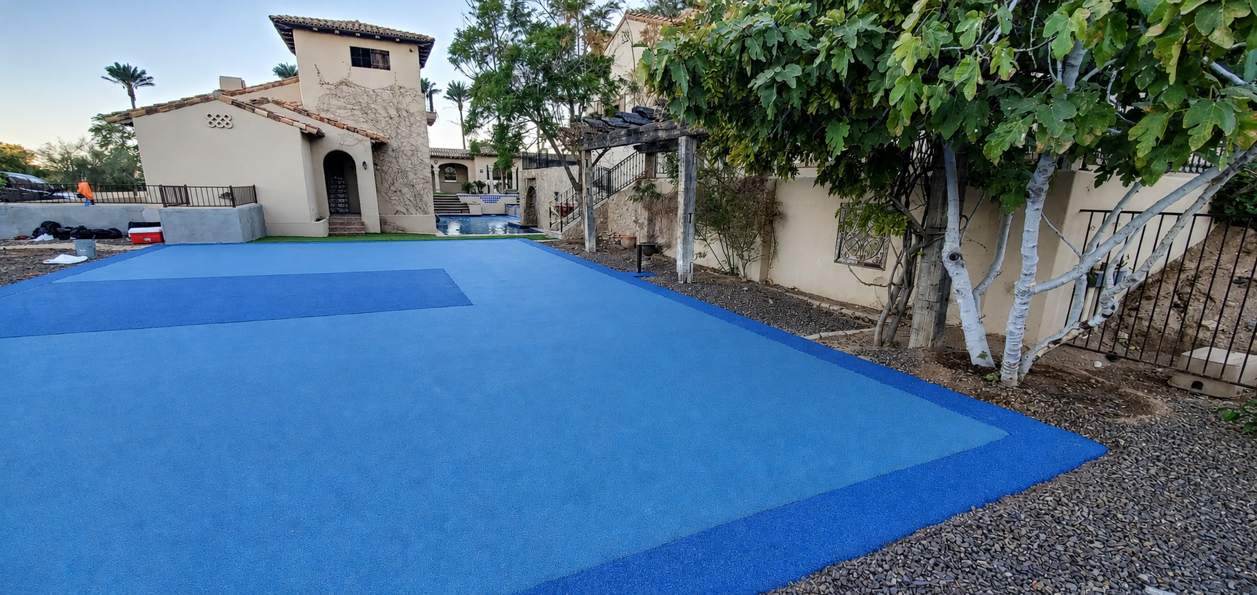 Blue rubber court at Spanish-style estate