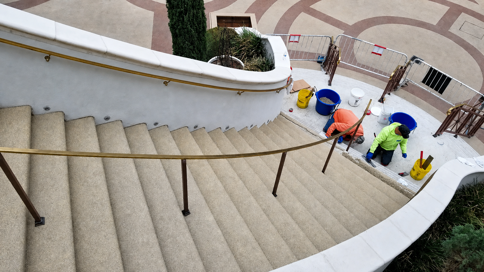 Workers applying rubber surfacing on curved staircase